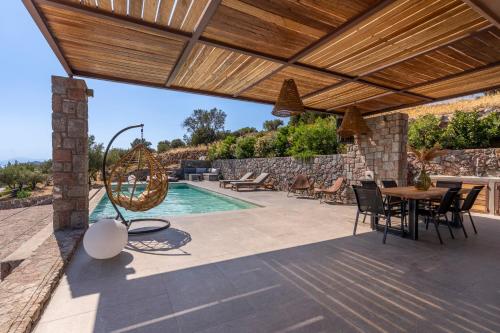 a patio with a table and chairs and a swimming pool at Villa Melisea in Sfendoúrion