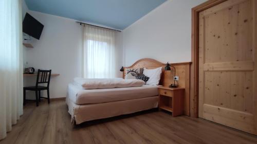 a bedroom with a bed and a chair and a door at Eco-Baita Natura Spensierata in Canale San Bovo