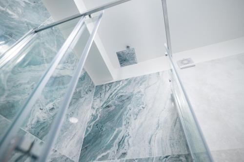 a shower in a bathroom with a glass wall at White Titanic Sea View in Mamaia Nord