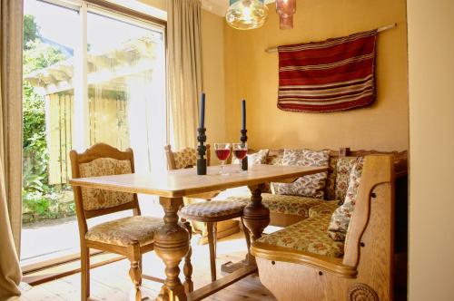 a dining room with a table and chairs and a couch at Abbotscot, near Bantham, an eccelectic property with a lovely garden in Bantham