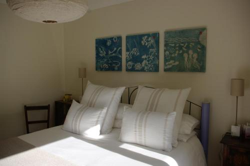a bedroom with a bed with white pillows at Abbotscot, near Bantham, an eccelectic property with a lovely garden in Bantham