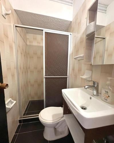 a bathroom with a toilet and a sink and a shower at Casa completa con aire acondicionado , Excelente ubicacion in Valledupar