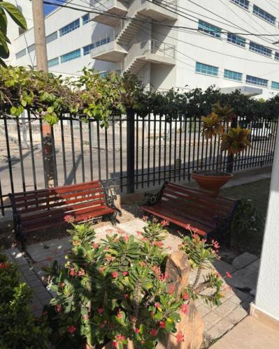 two wooden benches sitting next to a fence at Casa completa con aire acondicionado , Excelente ubicacion in Valledupar