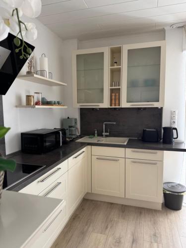 a kitchen with white cabinets and a sink at ZwoLu Apartments in Bornheim