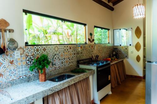 a kitchen with a sink and a window at Pariri Suites in Trancoso