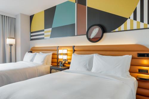 a hotel room with two beds and a mirror at Hyatt Centric Chicago Ohare in Rosemont