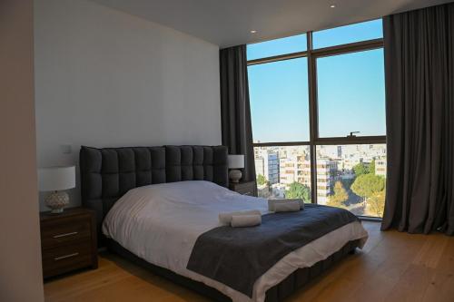 a bedroom with a large bed with a large window at The 1 -Nicosia Luxe Stay- Gym Pool 24h Concierge in Nicosia