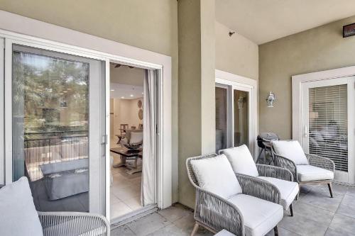 a porch with chairs and a sliding glass door at Salty Breeze in Saint Simons Island
