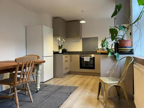 eine Küche mit einem Tisch, 2 Stühlen, einem Tisch und einem Kühlschrank in der Unterkunft 2 bedroom cottage in Kingsbridge in Kingsbridge