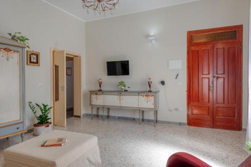 a living room with a red door and a tv at Casa Degli Zii in Salento in Trepuzzi