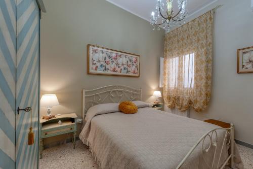 a bedroom with a bed and a window and a chandelier at Casa Degli Zii in Salento in Trepuzzi