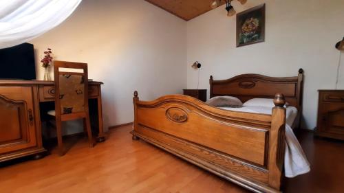 a bedroom with a wooden bed and a table at Sarokhaz Panzio in Vecsés