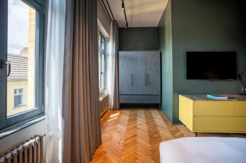 a bedroom with a bed and a dresser and a window at sly Berlin in Berlin