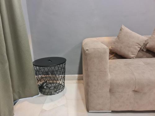a living room with a brown couch and a black stool at 10pax BAYU BEACH, SEASIDE, WATERSPORT, Pool, Bbq, Wifi, 50"TV in Port Dickson