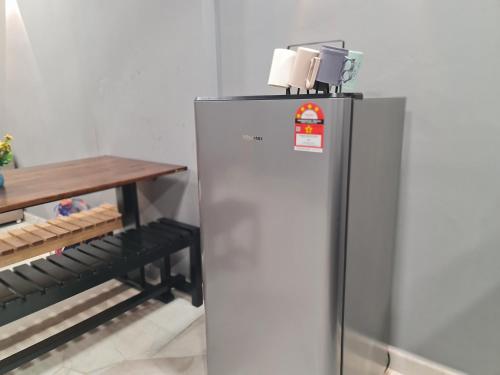 a stainless steel refrigerator in a kitchen with a table at 10pax BAYU BEACH, SEASIDE, WATERSPORT, Pool, Bbq, Wifi, 50"TV in Port Dickson