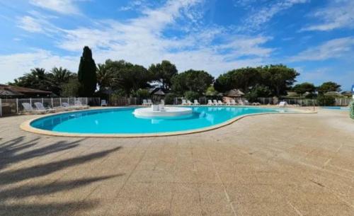 a swimming pool in a resort with a blue sky at 5 min du village de Noël Barcarès mas de pêcheurs 8 couchages tout confort in Le Barcarès
