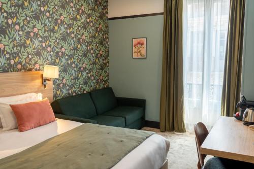 a hotel room with a bed and a couch at Hôtel de France, un hôtel AMMI in Nice