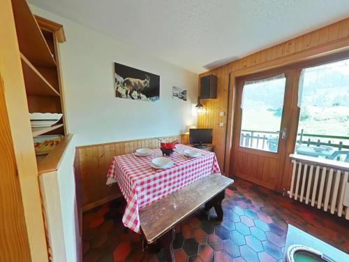 une chambre avec une table et un chiffon de table rouge et blanc dans l'établissement Charmant 2 pièces + mezzanine, centre Chinaillon, balcon sud, parking privé - FR-1-241-190, au Grand-Bornand