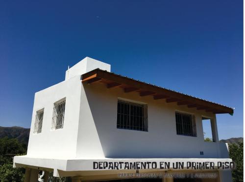 a white building with a sign in front of it at Complejo BIALET MASSE in Bialet Massé