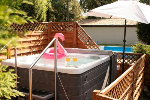 a pink flamingo in a hot tub with two glasses at Neptun Ośrodek Wypoczynkowy in Jantar