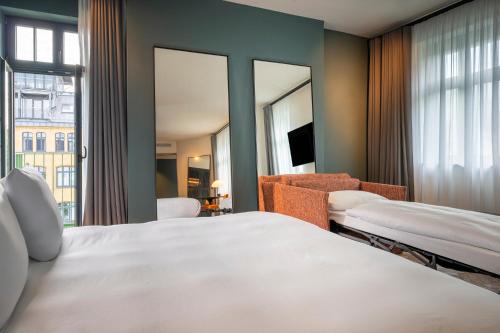 a hotel room with two beds and a mirror at sly Berlin in Berlin
