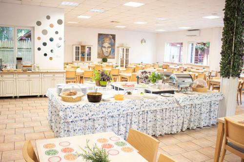 a dining room with tables and chairs in a restaurant at Neptun Ośrodek Wypoczynkowy in Jantar