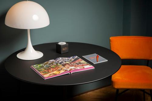 a black table with a lamp and a book on it at sly Berlin in Berlin