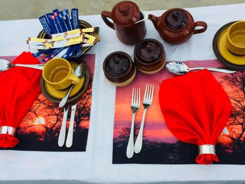 a table with utensils and a red napkin on a table at Amanya Star Bed Amboseli in Amboseli