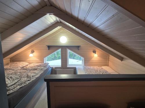 a attic room with two beds and a window at Holavegur 1 in Úthlid