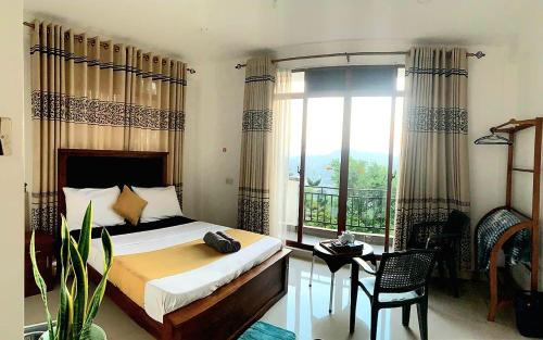 a bedroom with a bed and a large window at Golden King Residence Kandy in Kandy