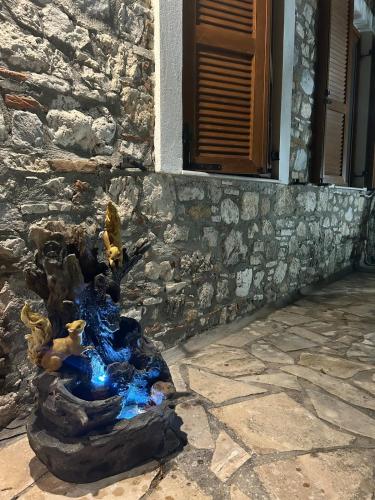 a water fountain in front of a stone building at Agora Serenity Retreat in Pythagoreio