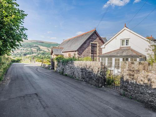 a house on a street with a stone wall at 2 Bed in Llangattock BN228 in Llangattock