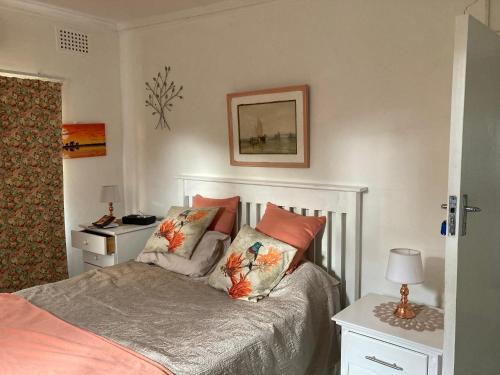 a bedroom with a bed with pillows on it at Mac Cottage in Park Rynie