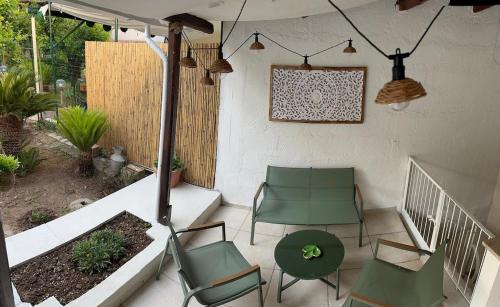 a patio with two green chairs and a table at Nonna Alba casa vacanza in Bari