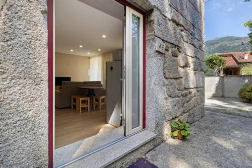 a glass door leading to a patio in a house at Sidro House - Alojamento No Gerês in Geres