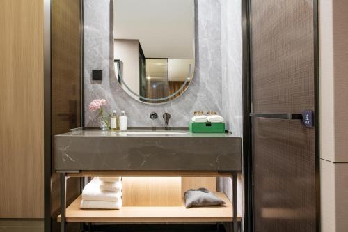 a bathroom with a sink and a mirror at Holiday Inn Guangzhou Zhujiang New Town - Free Shuttle Bus to Canton Fair Complex & Overseas Buyer Registration Services during Canton Fair Period in Guangzhou