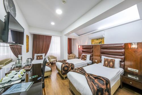 a hotel room with two beds and a desk at Marlight Boutique Hotel in Izmir