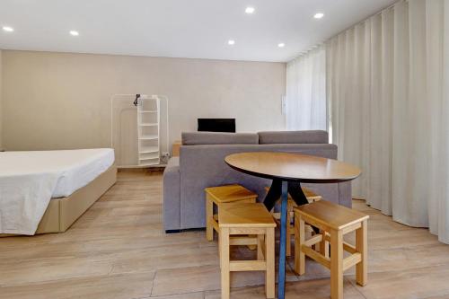 a bedroom with a bed and a table and a couch at Sidro House - Alojamento No Gerês in Geres