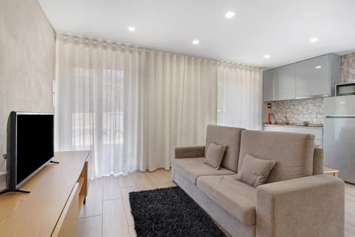 a living room with a couch and a television at Sidro House - Alojamento No Gerês in Geres