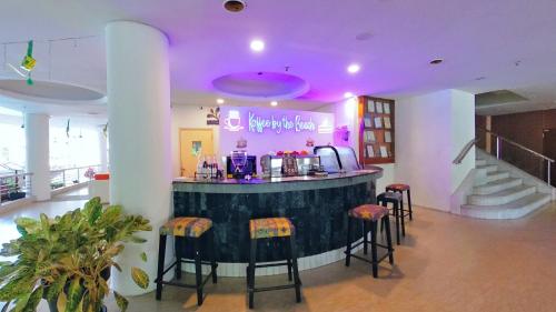 a bar with stools in a room with purple lighting at 10pax BAYU BEACH, SEASIDE, WATERSPORT, Pool, Bbq, Wifi, 50"TV in Port Dickson