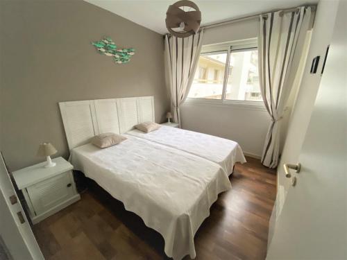 une chambre avec un lit blanc et une fenêtre dans l'établissement Appartement Moderne 6 Pers, Centre d'Arcachon, Parking Sécu, Ascenseur, Ménage Inclus - FR-1-474-97, à Arcachon