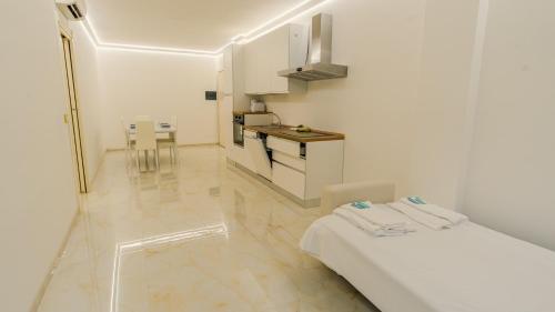 a white room with a bed and a kitchen at Relais du Lac Village - Italian Homing in Desenzano del Garda