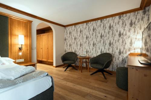 Ένα ή περισσότερα κρεβάτια σε δωμάτιο στο Alpin & Vital Hotel La Perla