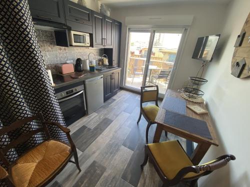 une cuisine avec une table et des chaises dans une pièce dans l'établissement Studio rénové avec clim et wifi au port de l'Aiguillon pour 2 - FR-1-474-214, à Arcachon