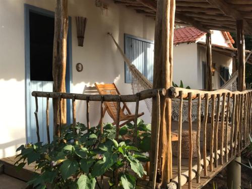 a porch of a house with a chair and a plant at Casa Vento Curimãs in Barroquinha