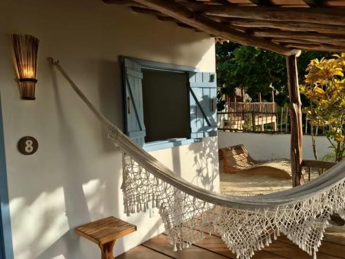 a hammock attached to a house with a window at Casa Vento Curimãs in Barroquinha