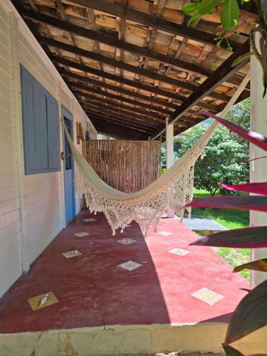 a hammock on the porch of a house at Casa Vento Curimãs in Barroquinha