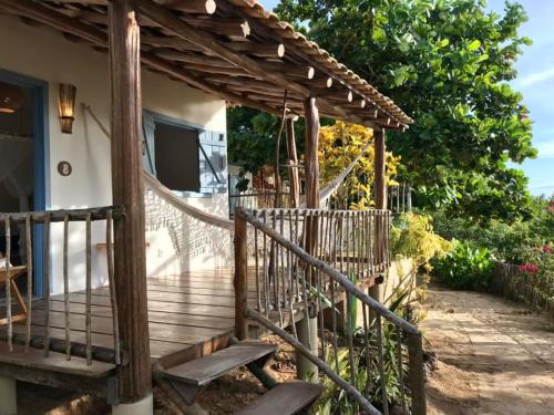 a wooden deck with a pergola in front of a house at Casa Vento Curimãs in Barroquinha