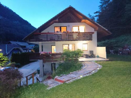 a house with a large balcony on top of it at Apartment Magnolia in Blejska Dobrava