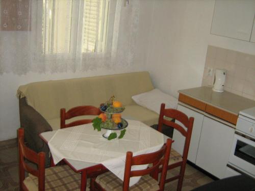 a small kitchen with a table and a table and chairs at Jarmila in Rogoznica